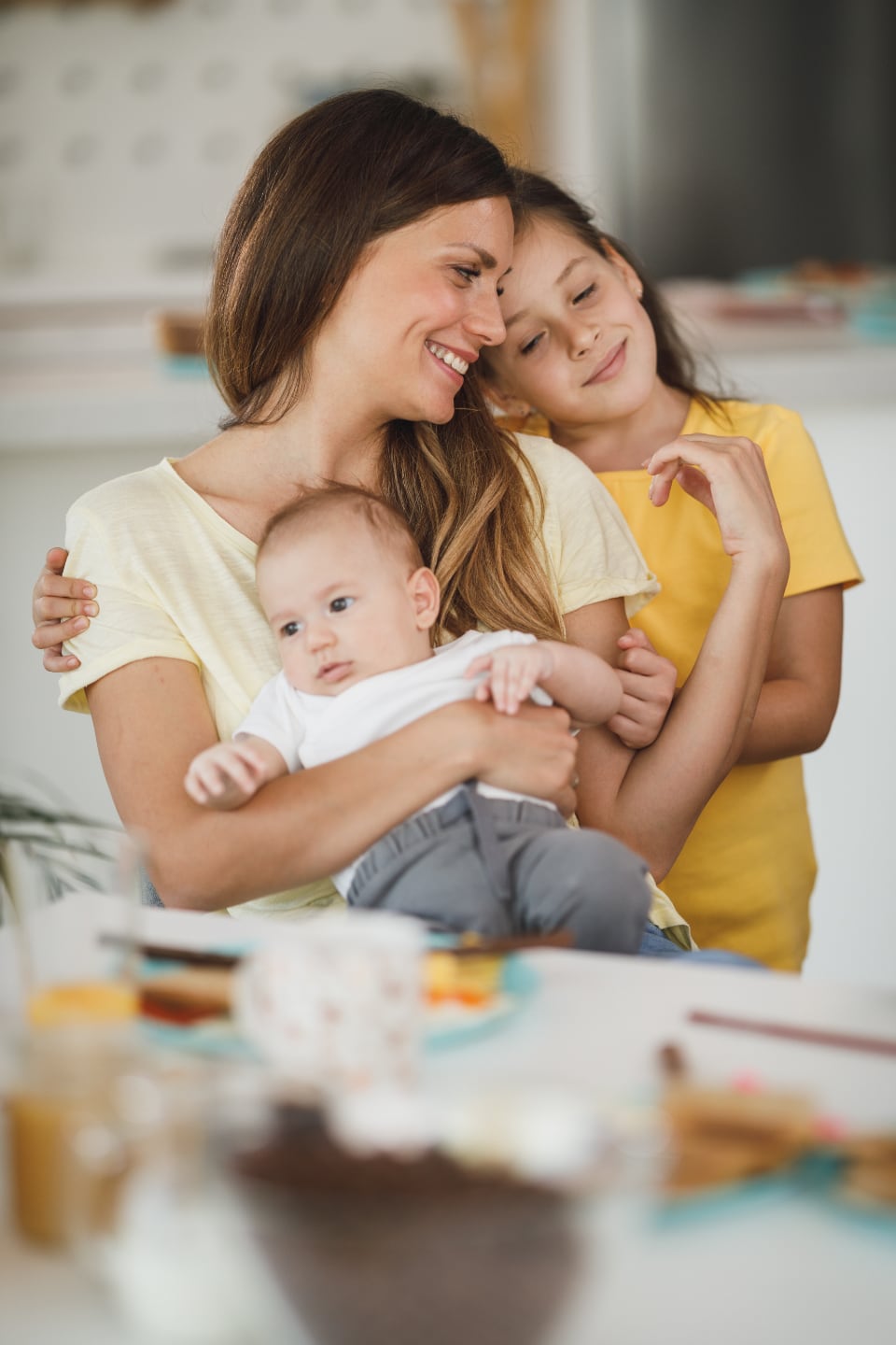 Smiling mother holding her baby on the sofa